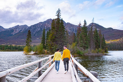 Rear view of people on lake against sky