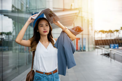 Portrait of young woman standing in city