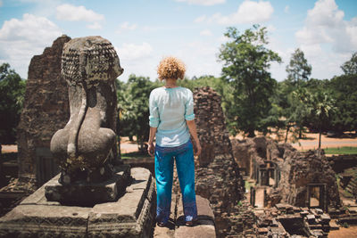 Rear view of mid adult woman standing at ankor wat temple