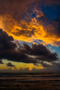 Scenic view of sea against dramatic sky during sunset