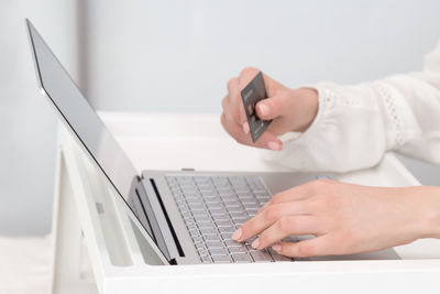 Midsection of man using laptop on table