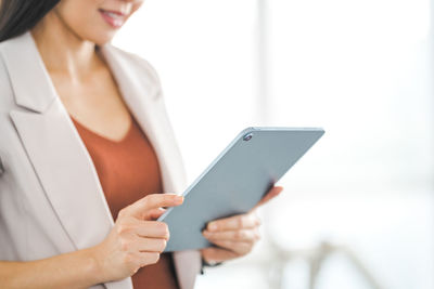 Midsection of woman using mobile phone