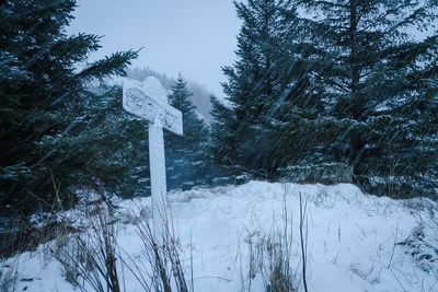 Low angle view of cross on snowcapped mountain during winter