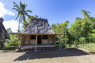 Built structure by trees against blue sky