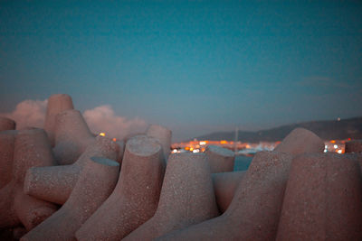 Close-up of illuminated candles against clear blue sky