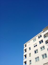 Low angle view of buildings against clear blue sky