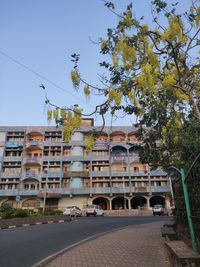 Street by buildings in city against sky
