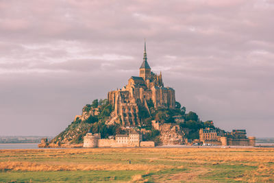 Old temple building against cloudy sky