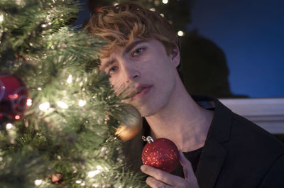 Portrait of woman holding christmas tree