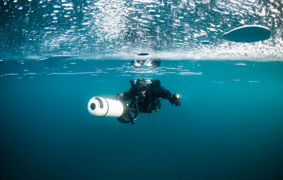 Reflection of man photographing in water