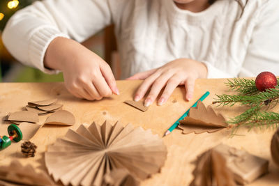 Midsection of woman with christmas decoration on table