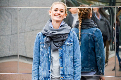 Portrait of smiling young woman standing in city