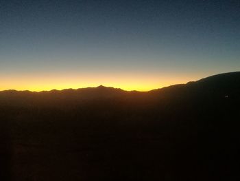 Silhouette landscape against clear sky during sunset