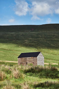 Barn on field against sky in wales