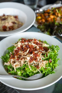 Salad with bacon and chicken, cesar salad background. lettuce salad close-up on a plate on a table.