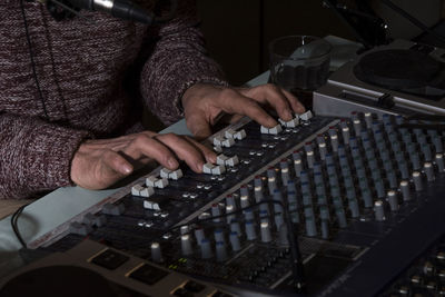 Midsection of dj playing sound mixer