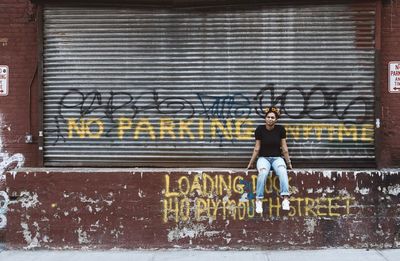 Full length of man standing by text in city