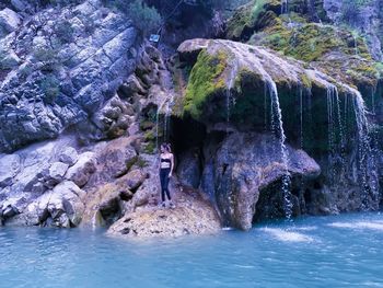 Full length of man standing on rock in sea