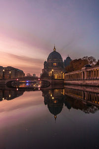 Reflection of illuminated buildings in city at dusk