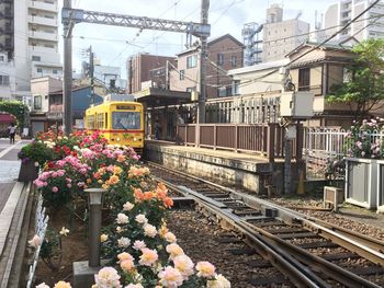 Train on railroad tracks in city against sky