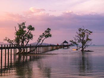 Scenic view of infinity long wooden pier over sea in sunset sky. koh mak island, trat, thailand.