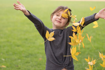Girl playing with leaves on land