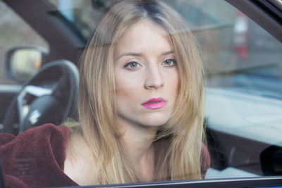 Portrait of beautiful young woman in car