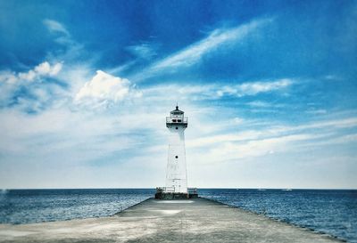 Lighthouse amidst sea against sky