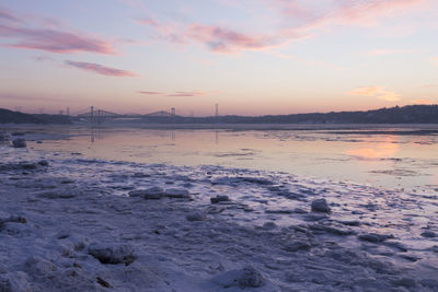 Pierre-laporte and quebec bridges over the partly frozen st. lawrence river seen on the horizon 