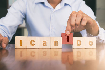 Midsection of businessman with text on toy blocks at desk