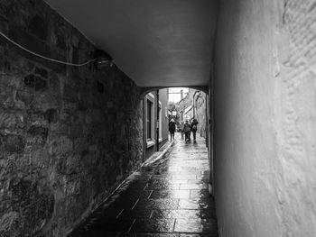 Rear view of people walking in tunnel