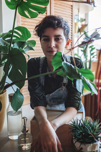 Portrait of young woman holding plant