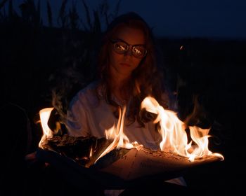 Young woman with fire in the dark