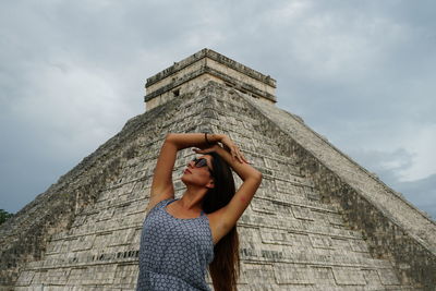 Low angle view of woman standing against sky