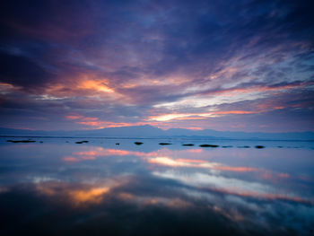 Scenic view of sea against dramatic sky during sunset