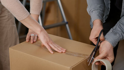 Midsection of man and woman packing box