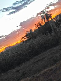 Scenic view of silhouette mountains against orange sky