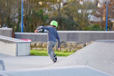 Full length of boy skateboarding at skateboard park