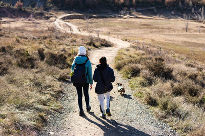 Mother and teen son spend time together with their dog sunshine cold day