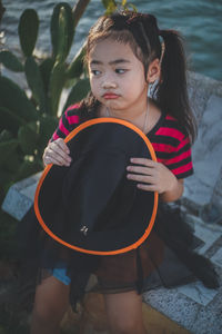 Girl holding witch hat looking away