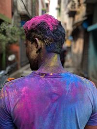 Rear view of messy man with powder paint