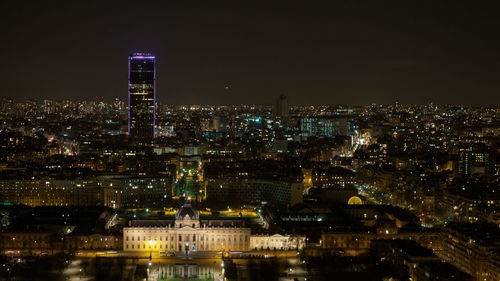 Illuminated buildings in city against sky at night