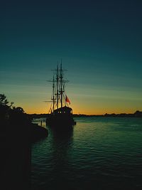 Boats in calm sea at sunset