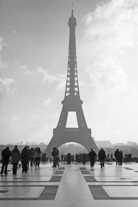 Tourists visiting tower against sky