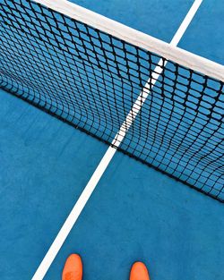 Low section of person standing on tennis court