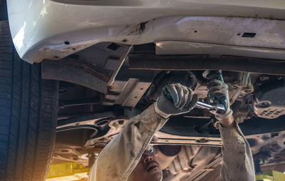 Low angle view of man repairing car in garage