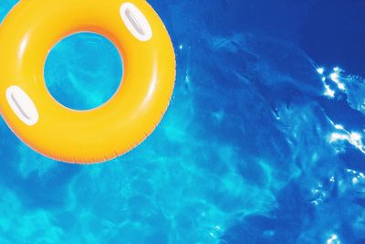 Yellow inflatable ring floating at swimming pool