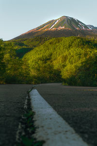 Scenic view of road by mountains against sky