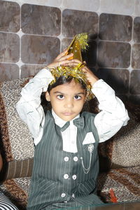 Portrait of cute girl standing against wall