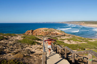 Girl walking down stairs to the beach